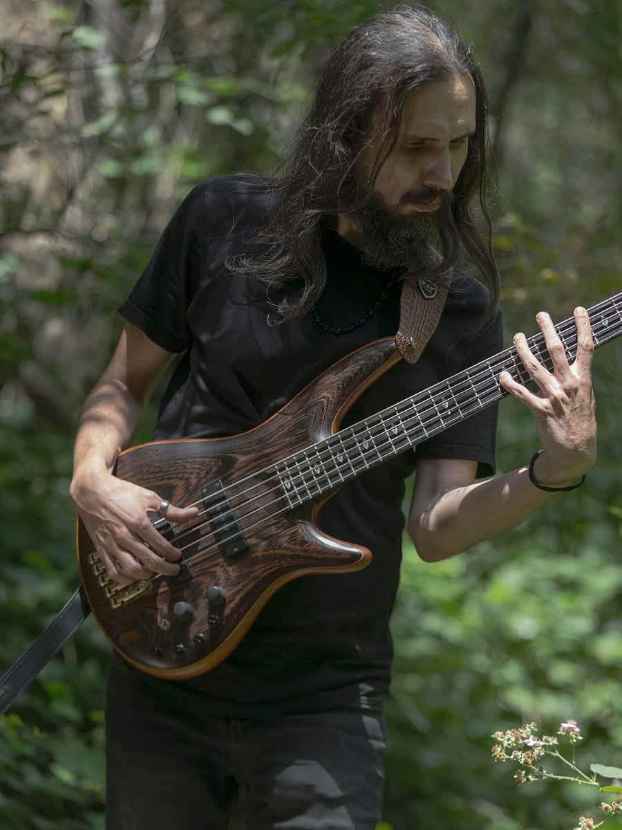Baixista tocando, mão no braço.